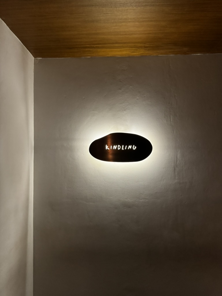 Minimal Kindling wall sign glowing in warm light