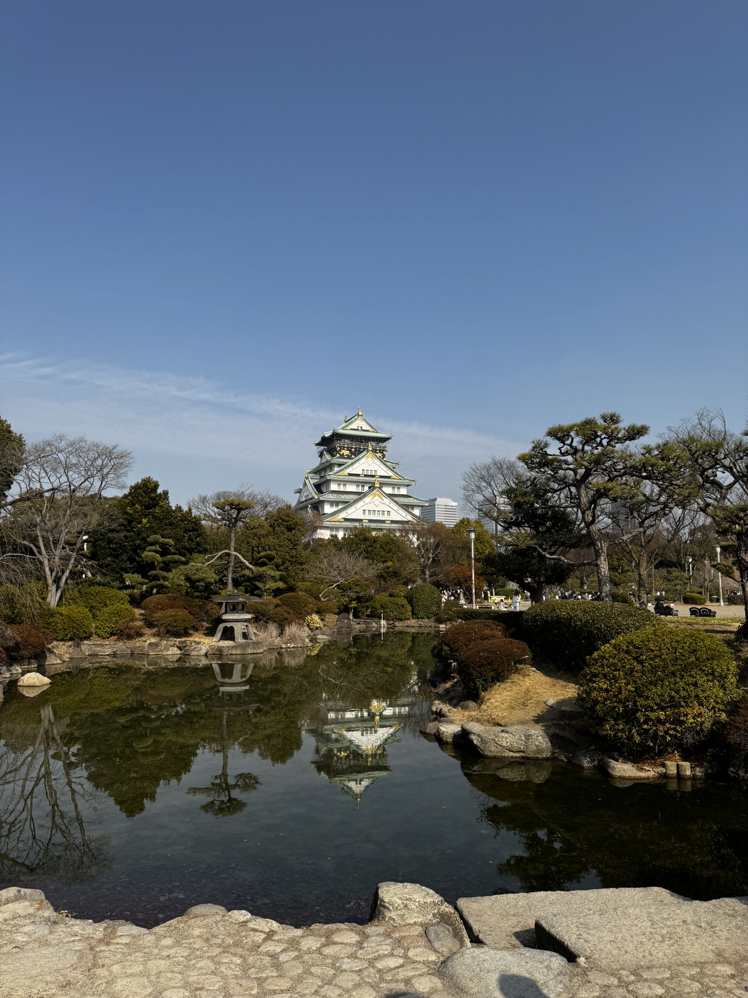 Osaka Castle reflected in a garden pond