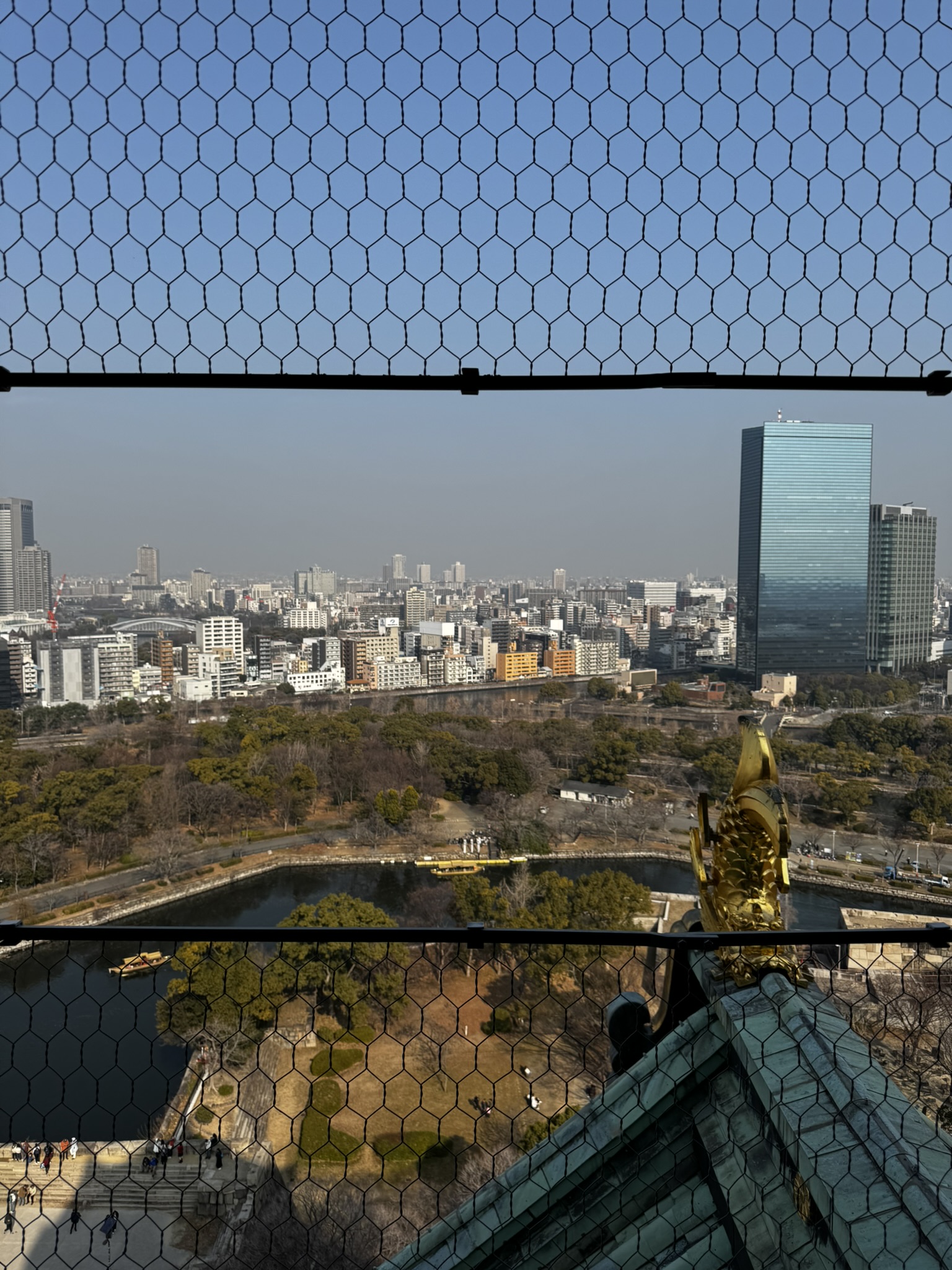 City view from Osaka Castle through a safety fence