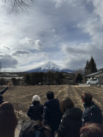 Tour group looking toward Mt. Fuji from an open field