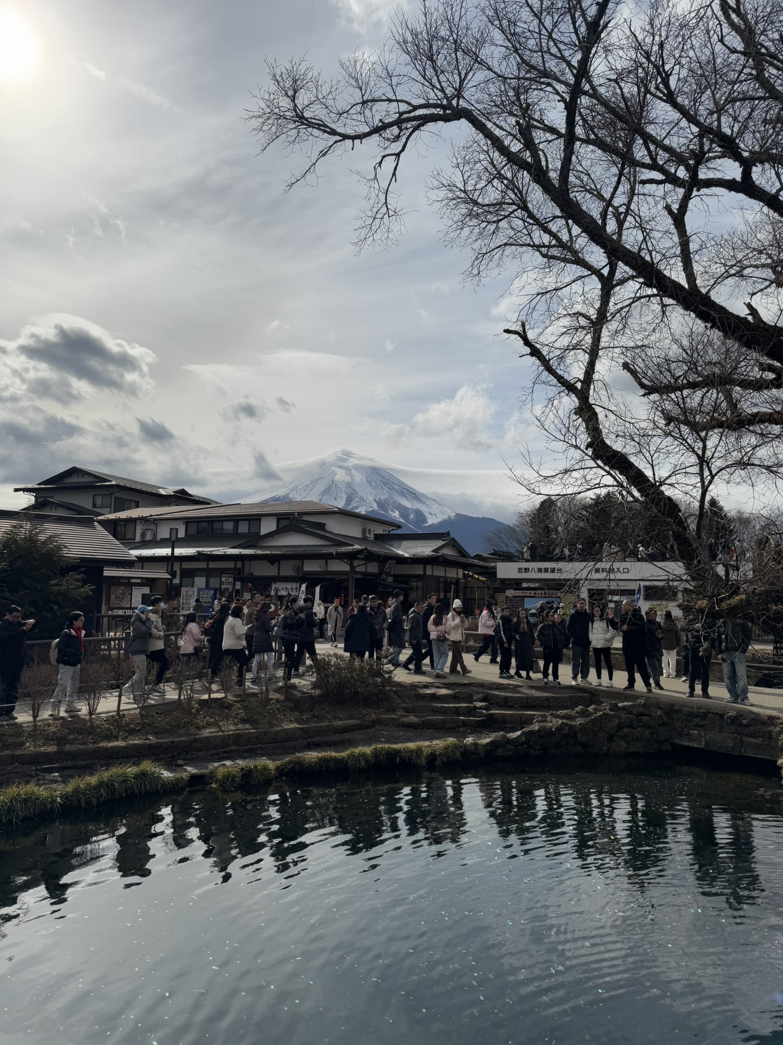 Mt. Fuji seen from Oshino Hakkai with water reflection and tourists