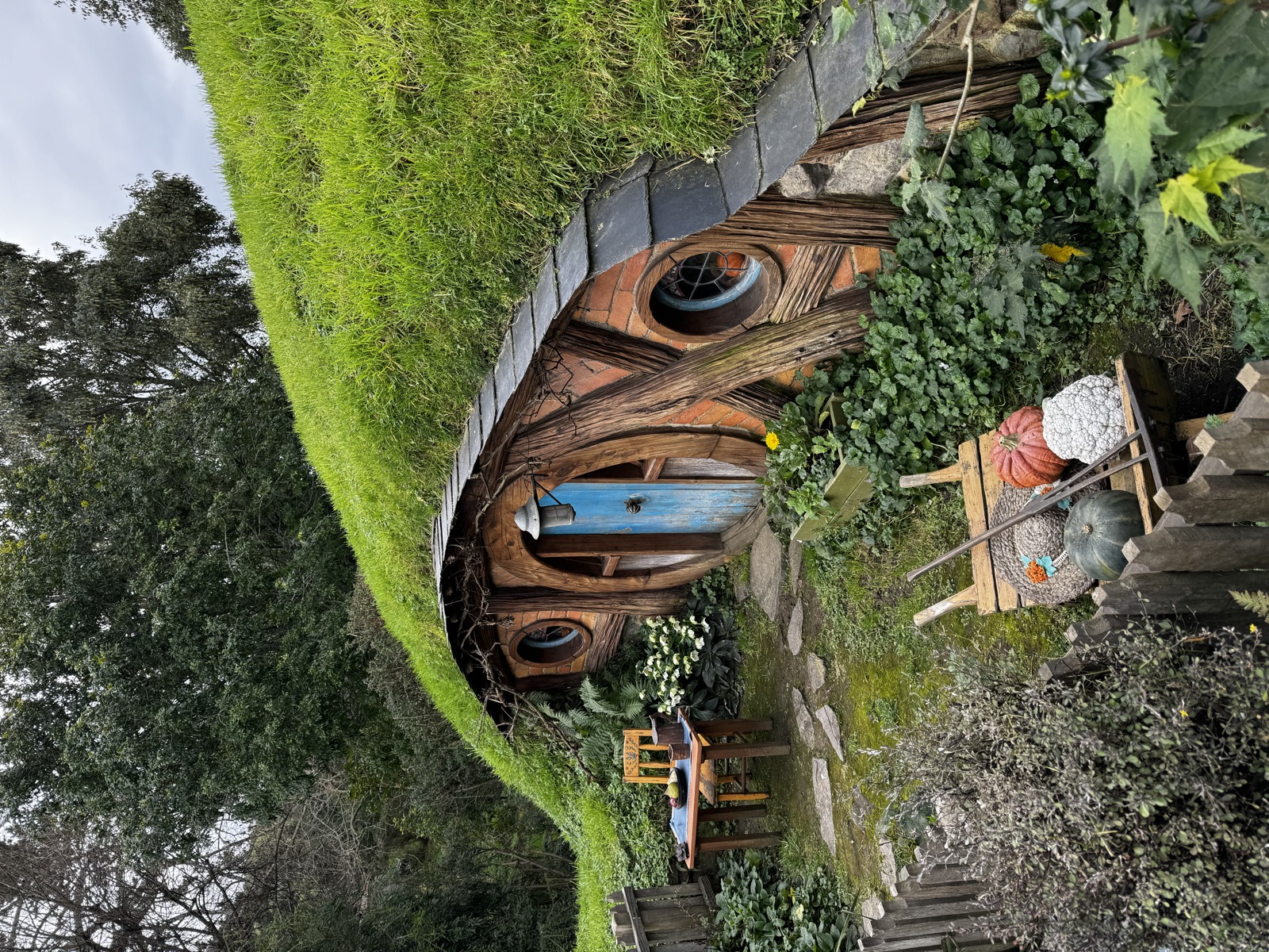 Round blue door set into a hillside cottage