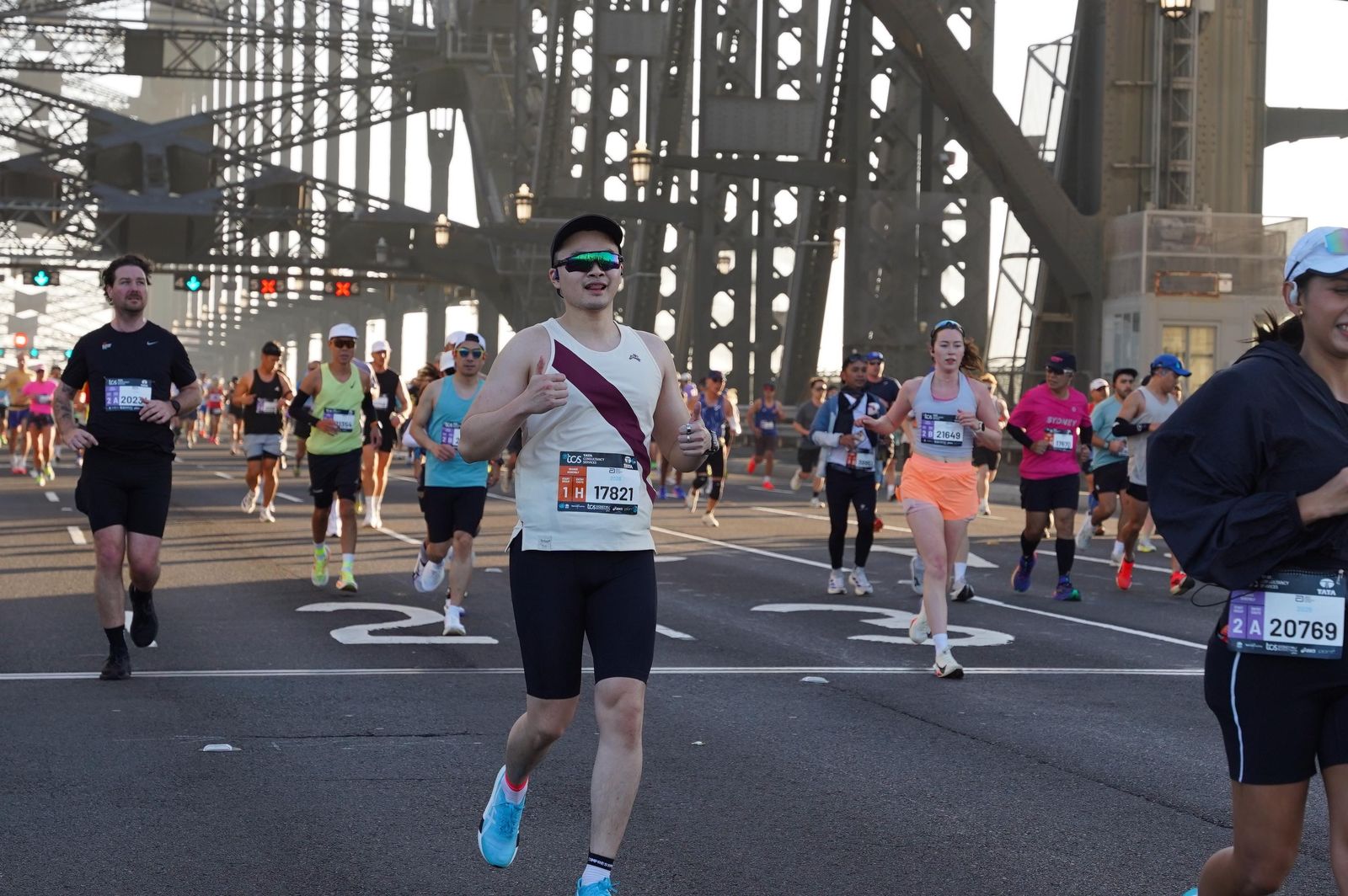 Runner giving a thumbs up while crossing the Sydney Harbour Bridge during the marathon